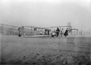 Glider being prepared for flight by Orville and assistants