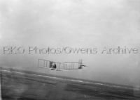 Orville Wright flying glider at a low altitude