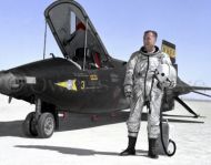 NASA test pilot Milt Thompson stands next to X-15