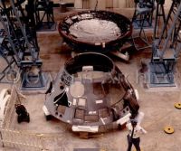 Officer stands guard in front of the disassembled Apollo 204 command module