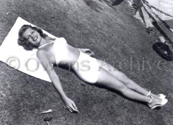 Rita Hayworth wearing swimsuit at home