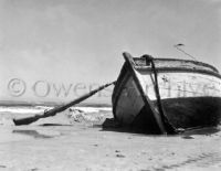 Row boat and rifle left on beach by Germans