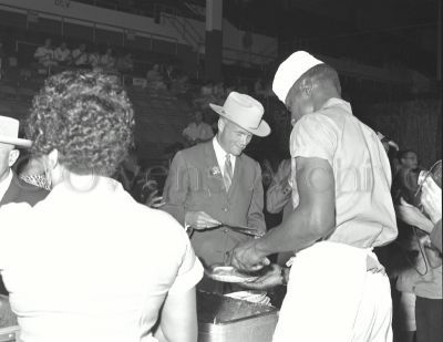 Mercury astronaut John H. Glenn serves food at Houston Coliseum