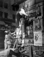 Fattie Arbuckle putting up a poster, NYC